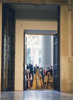 Paus Johannes Paulus II opent de Heilige Deur van de Sint-Paulus buiten de Muren, geflankeerd door de aartbisschop van Canterbury, George Carey, en Metropolitiet Athanasio op 18 januari 2000.  Op de achtergrond staat kardinaal Joseph Ratzinger (van 2005-2013 was hij paus Benedictus XVI).; Foto Foto
