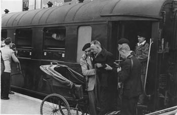 Een deelnemer aan een KAB bedevaart naar Lourdes wordt door brancardiers in een wagentje geholpen; Foto Foto