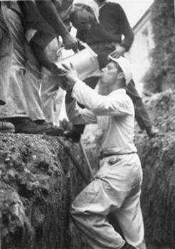 Een deelnemer aan een kamp van de bouworde in het Duitse Ellwangen wordt door zijn kameraden van drinkwater voorzien; Foto Foto
