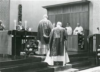 Een bijeenkomst van het NKOV wordt geopend met een mis in de Walburgiskerk. De priester op de bovenste trede van het altaar waarvan we de rug zien, is kardinaal Alfrink; Foto Foto