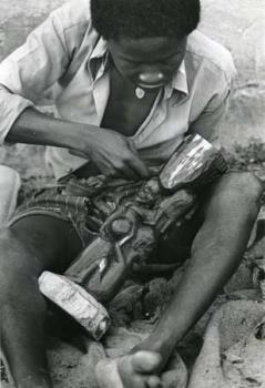 Tanzania/Man die een houten beeld aan het maken is.; Foto Foto