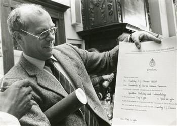 Jan Willemsen van Bureau Buitenland toontt het certificaat dat de Tanzaniaanse tandheelkundige Dr. Mushtag H.G. Dhirani zojuist uit handen van A.J.M. Plasschaert ontvangen heeft; Foto Foto
