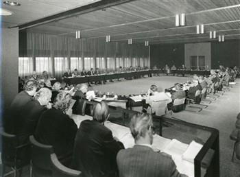 Een vergadering van de Ziekenfondsraad. W.L.P.M. de Kort -aan de overkant van de tafel zit hij vlak bij de deur- zit de vergadering voor; Foto Foto