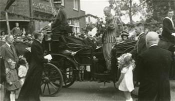 Terugkeer van pastoor Schaars uit het concentratiekamp. De geestelijke met een boek in zijn hand is kapelaan Veeger; Foto Foto