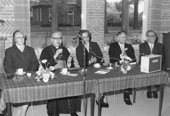 Tijdens een bezoek aan de St. Nicolaasstichting in Denekamp zit kardinaal Alfrink met enige zusters en secretaris Zemann (links) en de de carmeliet Emile Gemmeke (rechts) aan tafel; Foto Foto