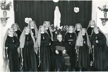 Mgr. A.G. Smit , de voorzitter van het Apostolaat der Hereniging met een groep zusters. Opschrift op achterzijde: "Zusters van de eenheid"; Foto Foto