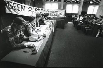 'Forum studenteninkomen', A'dam/ Aula UvA', In het forum van links naar rechts Lankhorst, den Ouden, Wolf, Lansink, Groenman, Onbekend. Met tekst op spandoek 'geen afbraak van het studenteninkomen'; Foto Foto