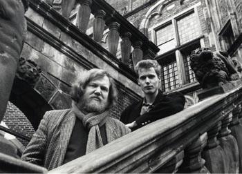 Twee onbekende personen, waarvan één met baard, op trappen op een onbekende locatie; Foto Foto