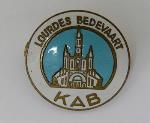 Medaille houdende een afbeelding van de kathedraal van Lourdes. Met tekst: 'Lourdes bedevaart KAB'. Met lint; Medaille Medaille