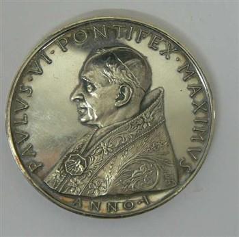Jaarpenning houdende een afbeelding van paus Paulus VI, met tekst: 'Paulus VI Pontifex Maximus Anno I Giampaoli'.
Keerzijde houdende een afbeelding van het embleem van het Vaticaan, met tekst: 'Corona Aurea super caput eius XXX.VI MCMLXIII'; Jaarpenning Jaarpenning