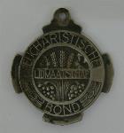 Medaille houdende een afbeelding van korenaren, met tekst: 'Lidmaatschap Eucharistische Bond'.
Keerzijde houdende een afbeelding van Jezus met het brood en de wijn; Medaille Medaille